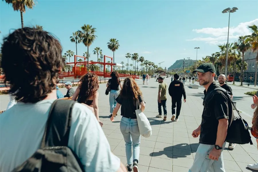 A team walking together along the palm-lined Barcelona waterfront