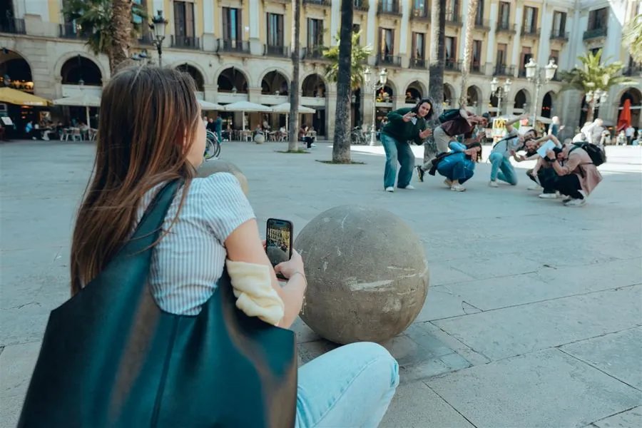 A participant capturing a playful photo of teammates in a Barcelona square