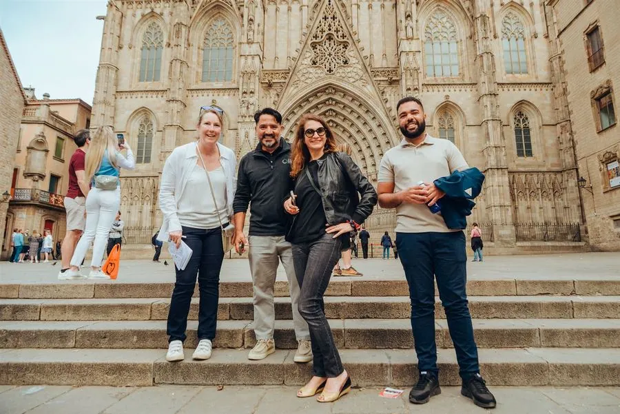 A team posing on Barcelona Cathedral's steps at dusk
